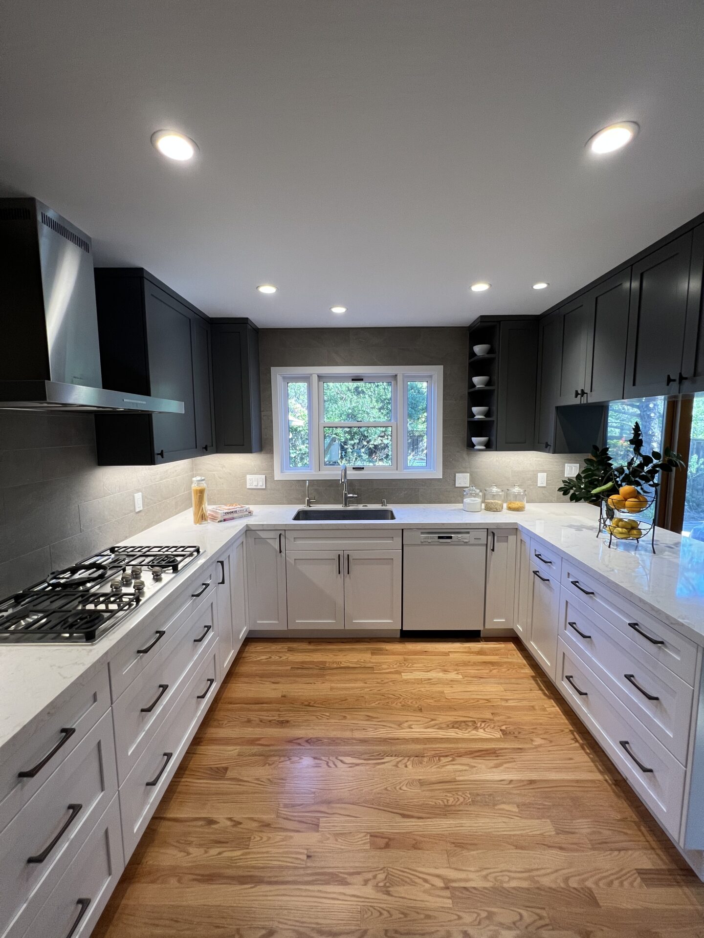 A U Shaped Kitchen With Black and White Color Cabins