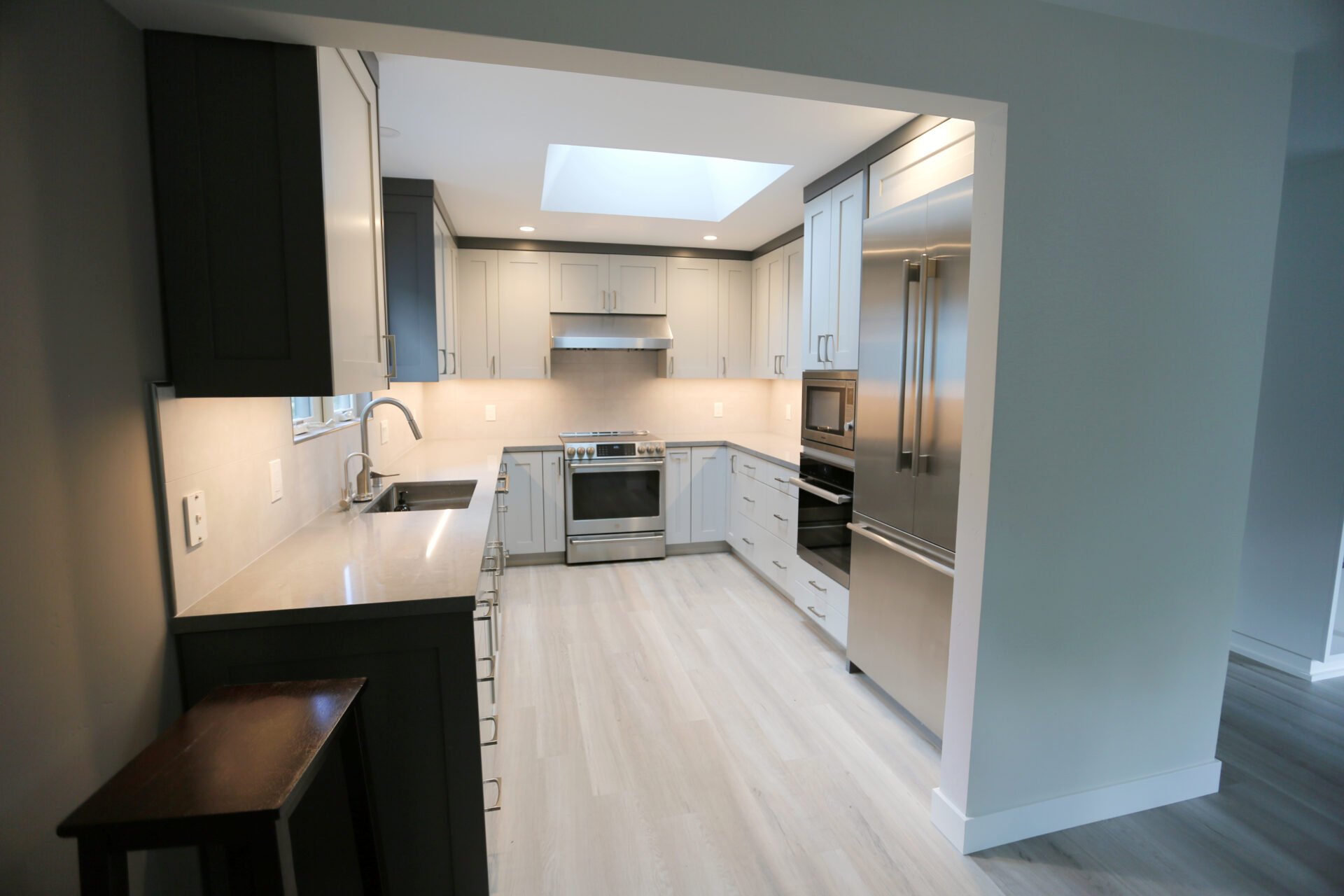 A U Shaped Kitchen With White Cabinet and Fridge