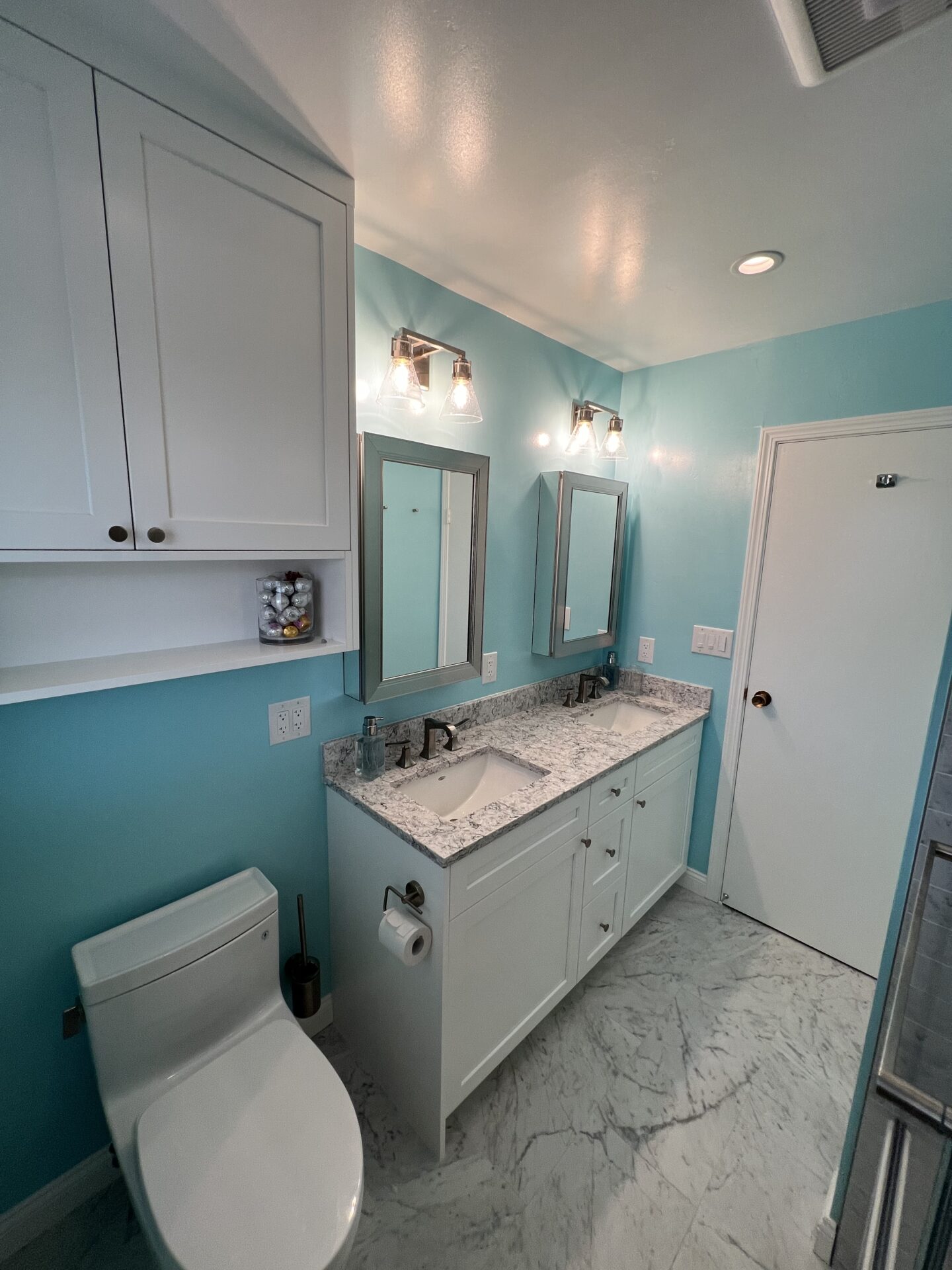 Bathroom with blue walls and white interiors